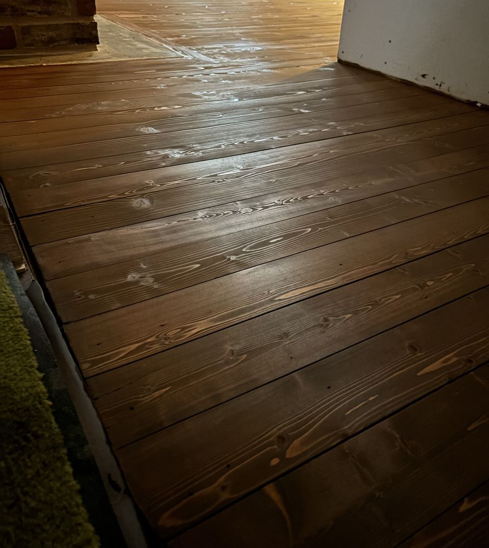Mörkt behandlat plankgolv i trä