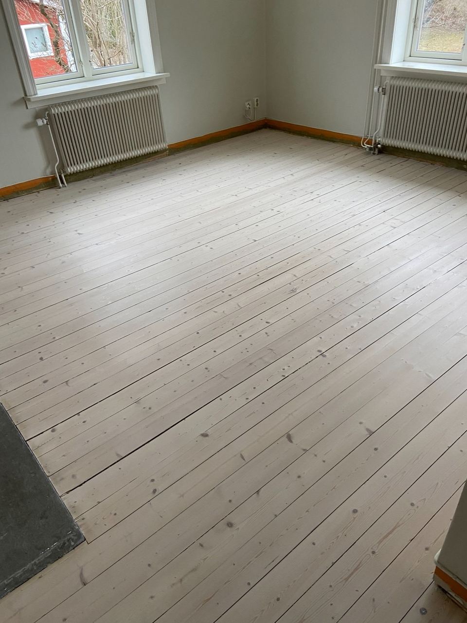 Vitlaserat furugolv i ljust rum