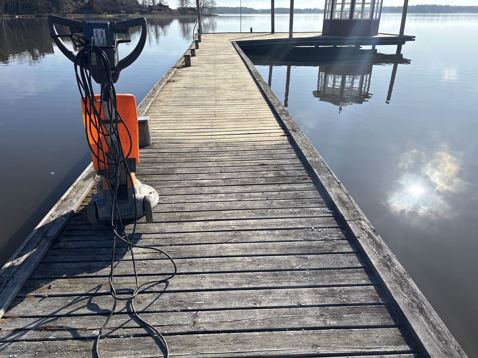 Golvslipmaskin på en träbrygga vid vattnet