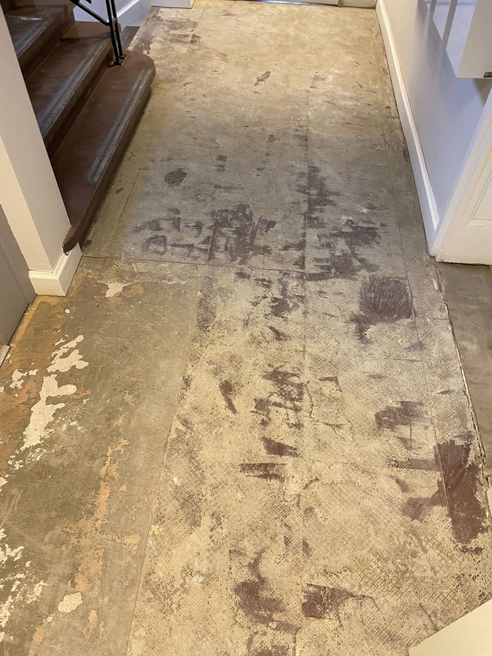 Slitet golv med gamla limrester före renovering