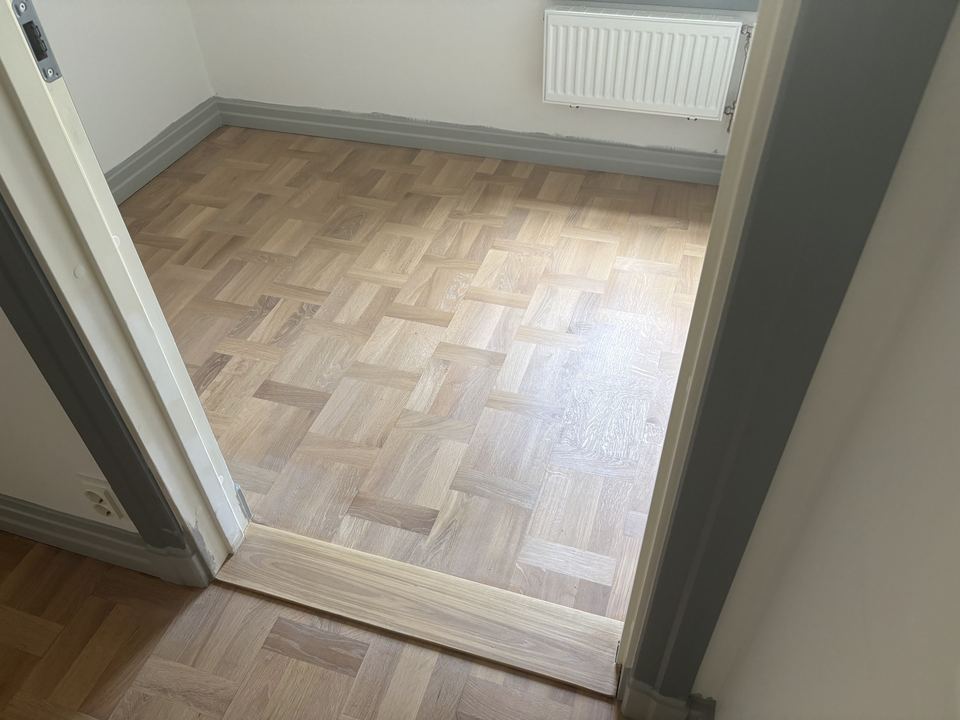 Mönsterparkett och ny tröskel sedd från dörröppningen